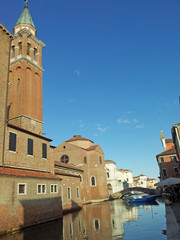 Obraz premium reflections of the medieval church in the Canal in Chioggia