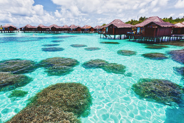 Over water bungalows and lagoon with coral