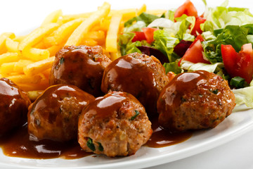 Roasted meatballs, French fries and vegetable salad