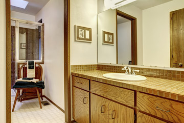 Outdated brown simple bathroom with one sink.