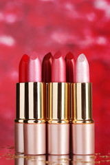 beautiful lipsticks on red background