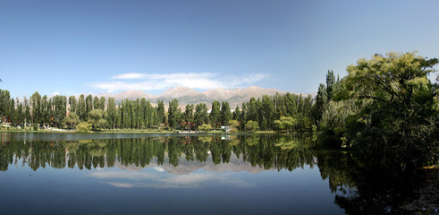 Obraz premium Panorama Freshwater lake with reflection of trees and sky