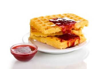 Tasty waffles with jam on plate isolated on white