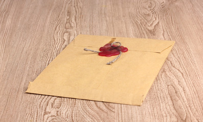 Envelope with sealing wax on wooden background