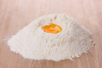 egg in flour on wooden table