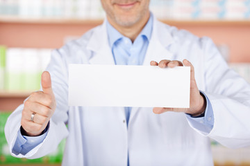 apotheker mit schild zeigt daumen hoch