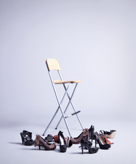 chair on gray background with many shoes