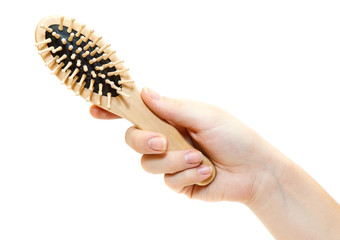 Female hand with wooden hairbrush isolated on white background