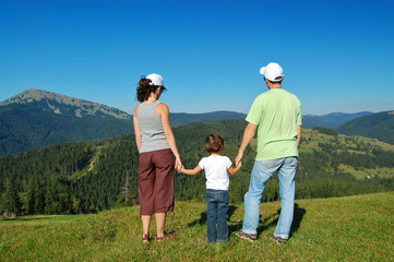 Family summer vacation in mountains. Active parents with kid