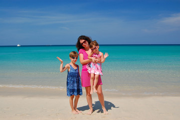 Family beach vacation. Happy mother with kids having fun