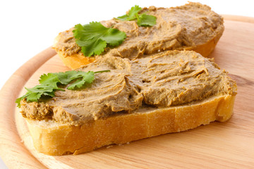 Fresh pate on bread on wooden board