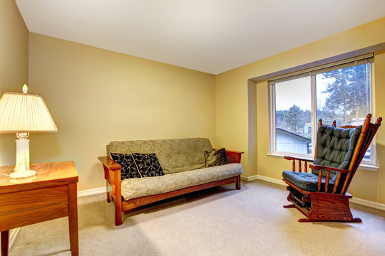 Simple room with old sofa and rocking chair.