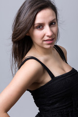 Fototapeta premium Beautiful young woman smiling, against a gray background