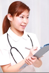 young japanese nurse with medical chart smiles