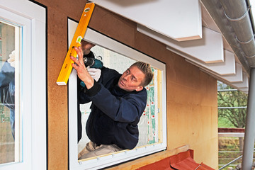 carpenter mounting a new window