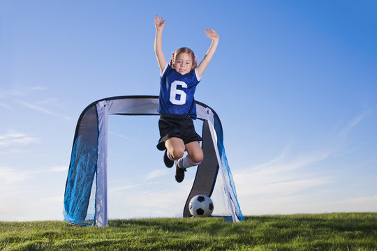 Young Girl Playing Soccer And Scoring Goal