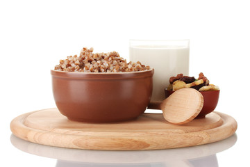 Boiled buckwheat in a brown bowl a glass of milk