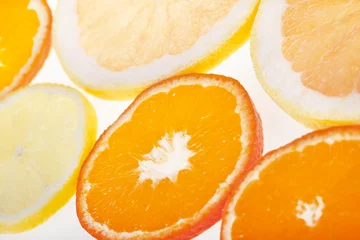 Rolgordijnen Verse plakjes citrusvruchten in studio-achtergrondverlichting © sitriel