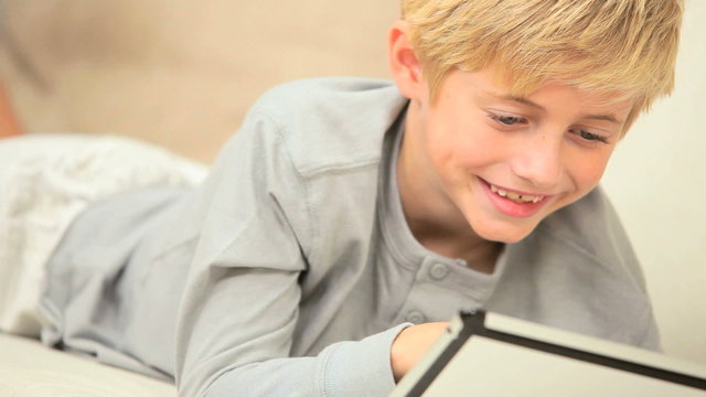 Young Blonde Boy Having Fun on Wireless Tablet