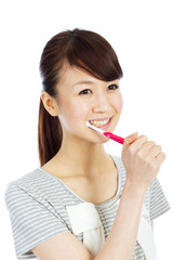 Beautiful young woman brushing her teeth
