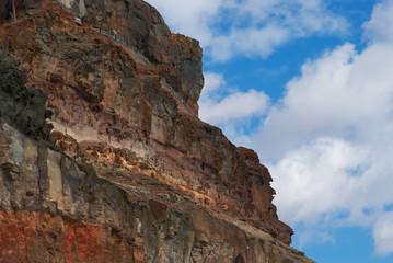 Brown volcanic cliff in sea
