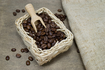 Fresh coffee beans in a basket with wooden scoop