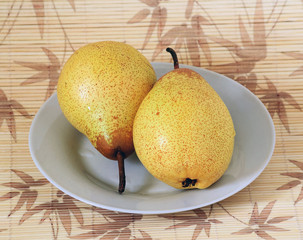 photographs of two pears on a plate located