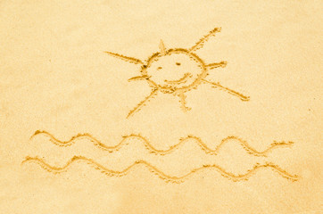 Smiling sun drawn on a sandy beach