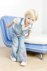 little girl standing by sofa