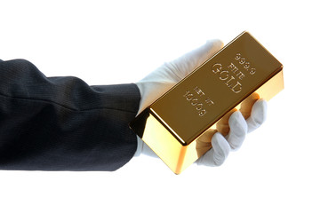 hand with glove holding a gold bar