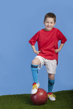 young boy in outfit with soccer ball