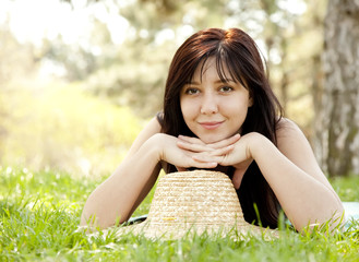 Beautiful brunette girl in hat at the park.