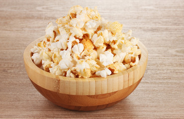 popcorn in wooden bowl on wooden table