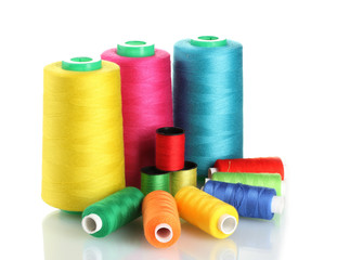 Many-coloured bobbins of thread isolated on white