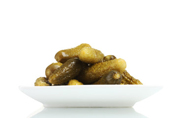 Marinated cucumbers on the plate isolated on white
