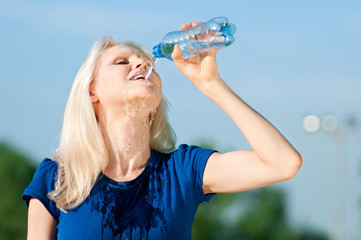 Woman drinking water at outdoors sport