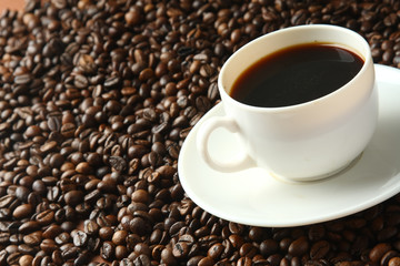 Fototapeta premium a cup of coffee on coffee beans, closeup