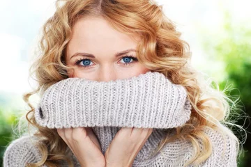 Poster Portrait of beautiful blond woman with wool sweater © goodluz