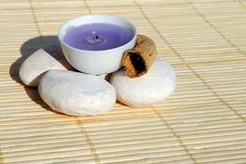 lighted purple candle on bamboo place mat