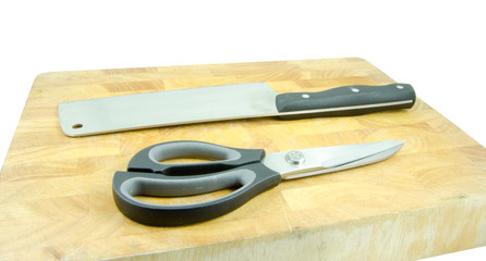 cleaver and scissors on wooden board