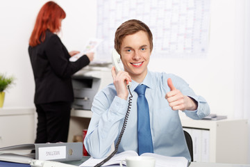 junger geschäftsmann führt erfolgreiches telefongespräch