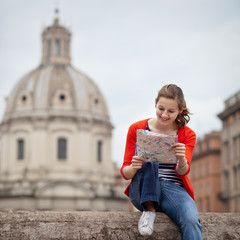 Pretty young female tourist studying a map at the Trajan's forum