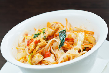 Spicy swordfish pieces with noodles and spring onions