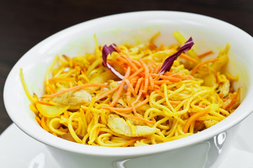 Curry chicken made with carrots, onions and noodles in wok