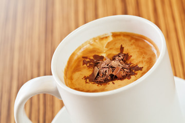 White cup of coffee with decoration on top of the cream