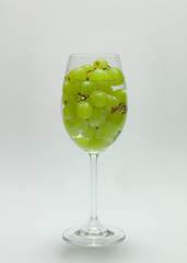 Rotweinglas mit Trauben im Wasser