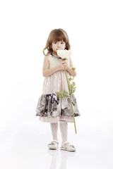 Summer smiling portrait of a little girl playing with a flower