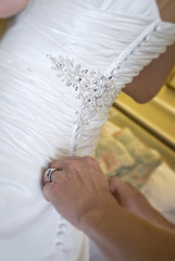 Bride being buttoned