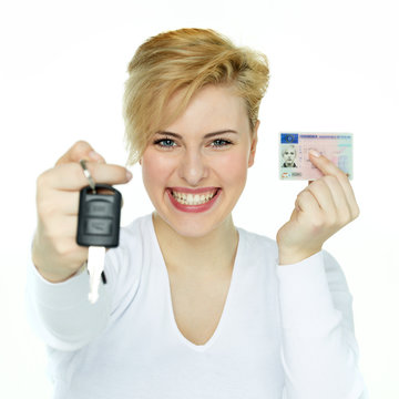 Young woman showing her driver licence and carkey