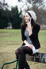 Young woman talking on the phone outdoors in a park